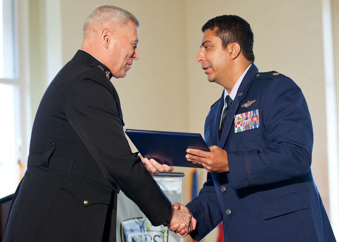 The Assistant Commandant of the Marine Corps, Gen. John M. Paxton, Jr., left, congratulates a graduate during the commencement ceremony at the Naval Postgraduate School, Monterey, Ca., Dec. 19, 2014. (U.S. Marine Corps photo by Cpl. Tia Dufour/Released)