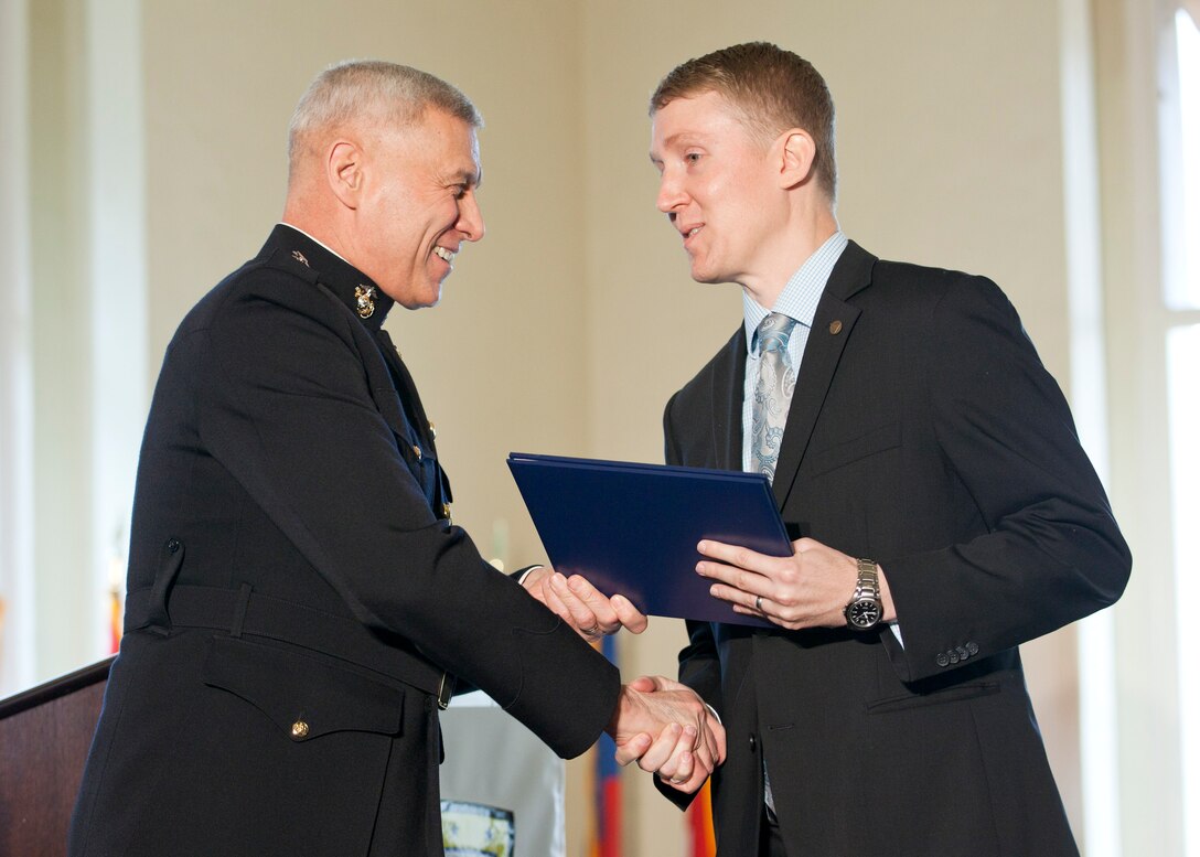 The Assistant Commandant of the Marine Corps, Gen. John M. Paxton, Jr., left, congratulates a graduate during the commencement ceremony at the Naval Postgraduate School, Monterey, Ca., Dec. 19, 2014. (U.S. Marine Corps photo by Cpl. Tia Dufour/Released)