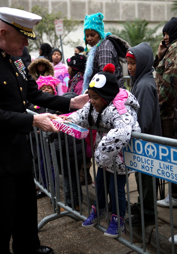 Lt. Gen. Richard P. Mills, commander of Marine Forces Reserve, hands a toy to a child during the ZULU Social Aid and Pleasure Club’s Toys for Tots distribution 
event at New Orleans City Hall, Dec. 20, 2014. Members of the club were joined by the general and Marines from MFR to pass out toys to hundreds of local children in need this holiday. 
