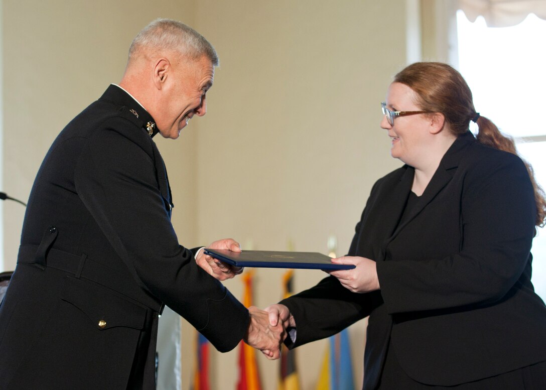 The Assistant Commandant of the Marine Corps, Gen. John M. Paxton, Jr., left, congratulates a graduate during the commencement ceremony at the Naval Postgraduate School, Monterey, Ca., Dec. 19, 2014. (U.S. Marine Corps photo by Cpl. Tia Dufour/Released)