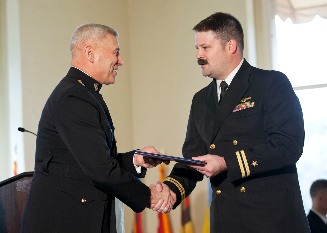 The Assistant Commandant of the Marine Corps, Gen. John M. Paxton, Jr., left, congratulates a graduate during the commencement ceremony at the Naval Postgraduate School, Monterey, Ca., Dec. 19, 2014. (U.S. Marine Corps photo by Cpl. Tia Dufour/Released)