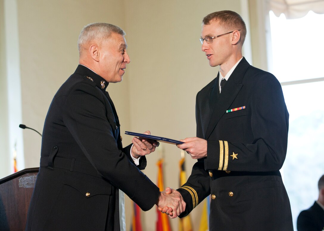 The Assistant Commandant of the Marine Corps, Gen. John M. Paxton, Jr., left, congratulates a graduate during the commencement ceremony at the Naval Postgraduate School, Monterey, Ca., Dec. 19, 2014. (U.S. Marine Corps photo by Cpl. Tia Dufour/Released)