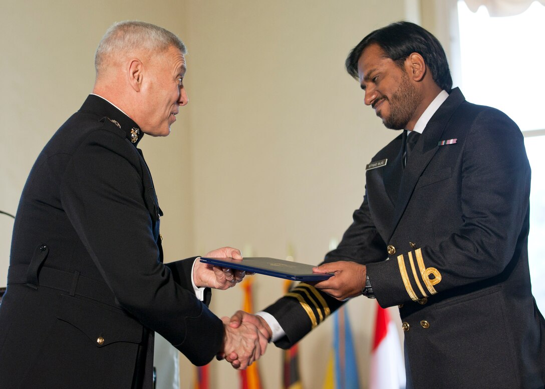 The Assistant Commandant of the Marine Corps, Gen. John M. Paxton, Jr., left, congratulates a graduate during the commencement ceremony at the Naval Postgraduate School, Monterey, Ca., Dec. 19, 2014. (U.S. Marine Corps photo by Cpl. Tia Dufour/Released)
