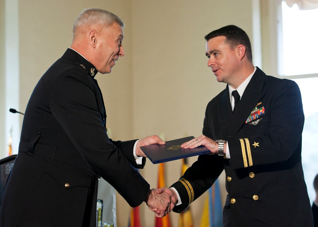 The Assistant Commandant of the Marine Corps, Gen. John M. Paxton, Jr., left, congratulates a graduate during the commencement ceremony at the Naval Postgraduate School, Monterey, Ca., Dec. 19, 2014. (U.S. Marine Corps photo by Cpl. Tia Dufour/Released)