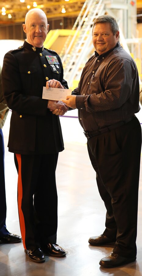 Lt. Gen. Richard P. Mills, commander of Marine Forces Reserve, receives a check from Bart Jones, general manager at Michoud Assembly Facility, as a donation to the Marine Corps Reserve Toys for Tots foundation, Dec. 19, 2014. Mills and fellow MARFORRES Marine and sailor volunteers went on a tour around the facility, seeing how the Space Launch System rocket is being made. (U.S. Marine Corps photo by Cpl. Brytani Musick)