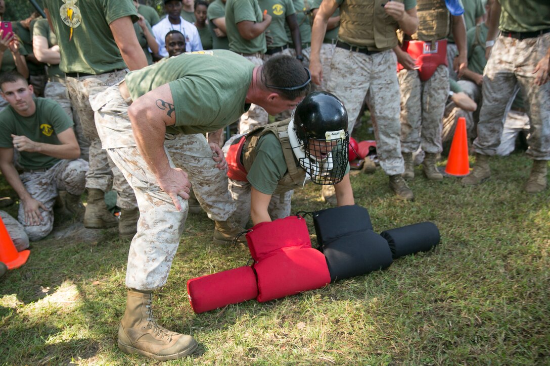 Staff Sgt. Canon Richard, left, a radio chief with 8th Communication Battalion, II Marine Expeditionary Force Headquarters Group, II Marine Expeditionary Force, motivates Lance Cpl. Nicolette White, a field radio operator with the battalion, during the “Praetorian Challenge” field meet aboard Camp Lejeune, N.C., Oct. 10, 2014. During the challenge, the Marines participated in warrior events such as rock climbing, tire flipping, pulling a 7-ton truck, and tug-of-war. (U.S. Marine Corps photo by Cpl. Elizabeth A. Case/Released)