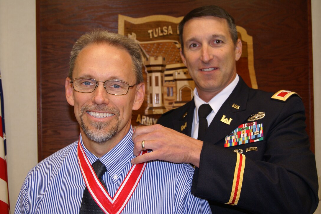 Col. Richard A. Pratt, commander, Tulsa District, U.S. Army Corps of Engineers presents Andrew Commer, Tulsa District's Chief of Regulatory Division, with the de Fleury medal for distinguished service to the Engineer Regiment.