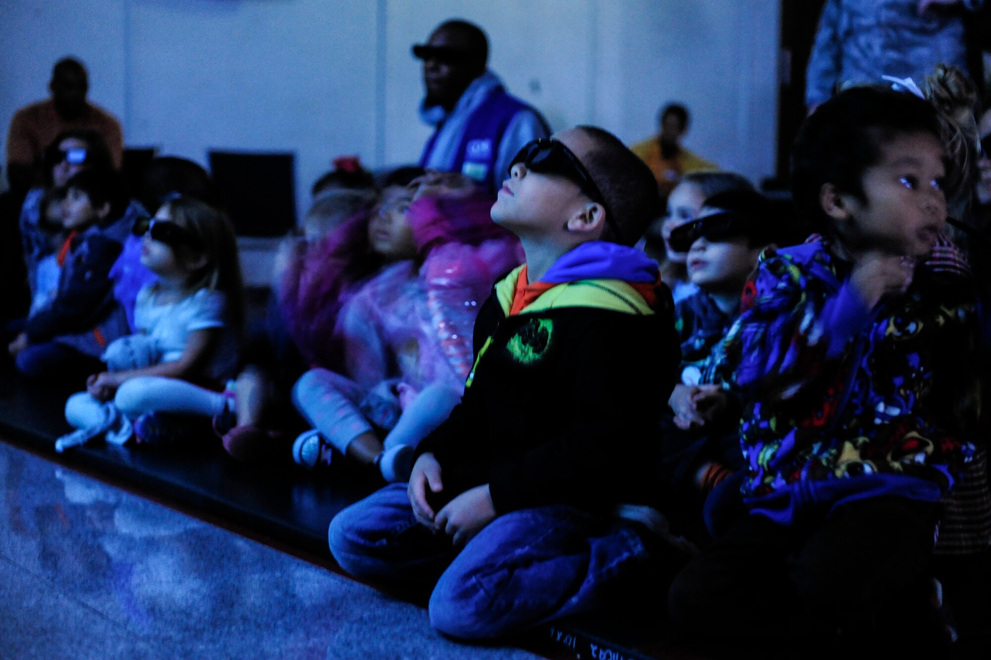 Children enrolled in the Kadena Child Development Center programs watch a 3D film on  Kadena Air Base, Japan, Dec. 22, 2014. They were visited by representatives from the Okinawa Churaumi Aquarium, who provided an interactive tour, entailing a viewing of an oceanic film and an up-close experience with a portable aquarium. More than 250 children visited the displays. (U.S. Air Force photo by Airman 1st Class John Linzmeier)