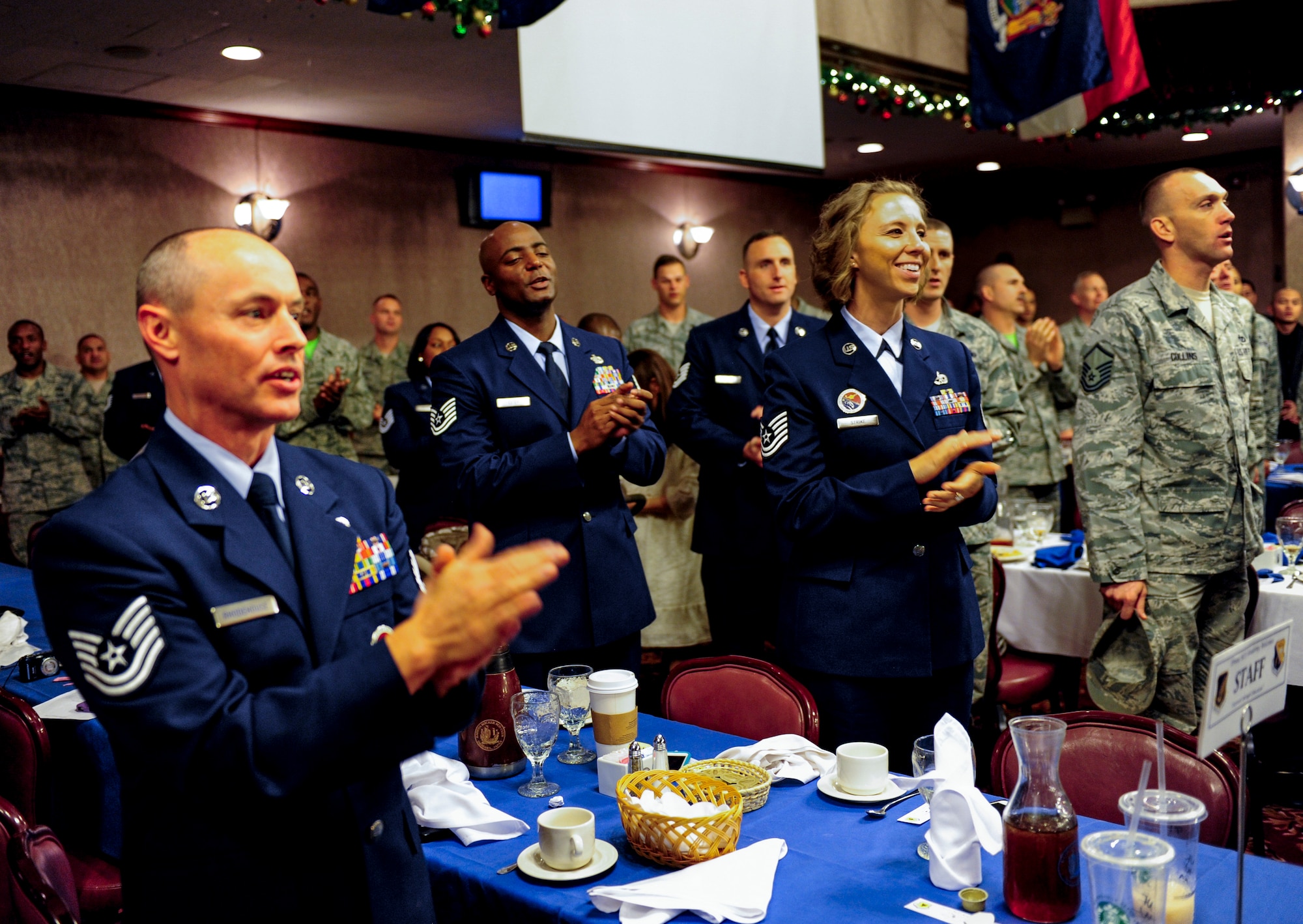 Graduates and instructors of NCO Academy class 15-1 clap their hands and sing the Air Force song after a graduation ceremony at the Rocker NCO Club, Kadena Air Base, Japan, Dec. 19, 2014. There were 51 graduates, including a U.S. Sailor, U.S. Marine and a member of the Japanese Air Self Defence Force. (U.S. Air Force photo by Airman 1st Class John Linzmeier)