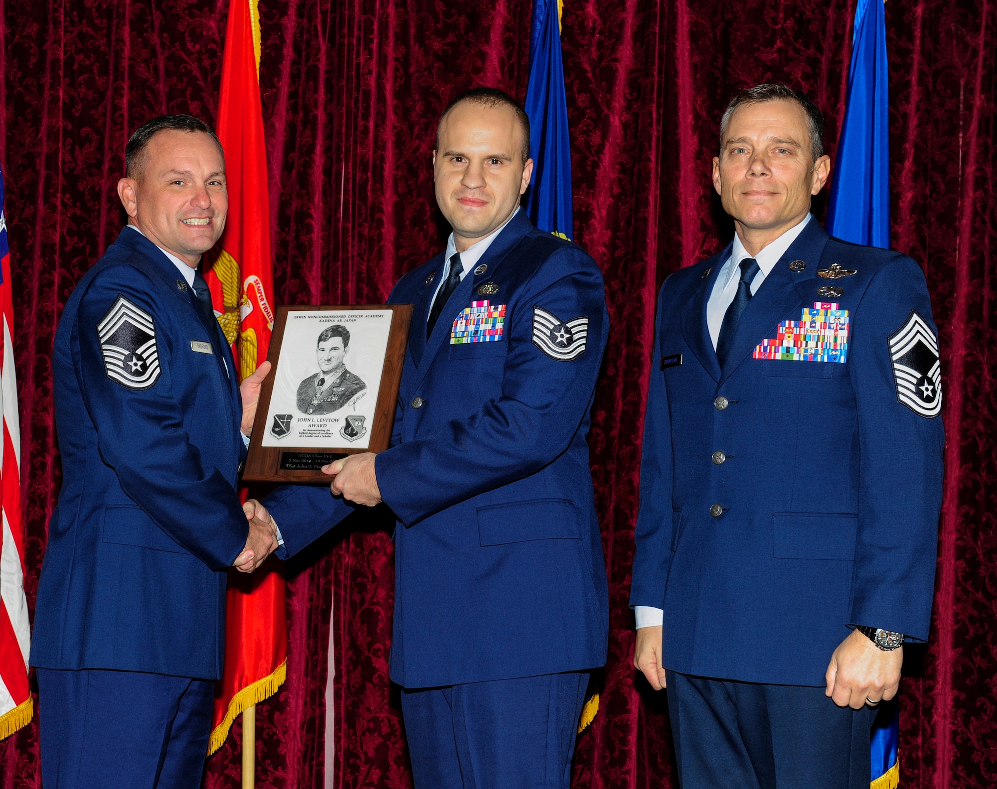 U.S. Air Force Tech. Sgt. John Frankenhoff, 664th Combat Communications Squadron, accepts the John L. Levitow Award during the graduation ceremony for NCO Academy Class 14-6 on Kadena Air Base, Japan, Dec. 19, 2014. The John L. Levitow Award is presented to the student who earns the highest average score on evaluations and most embodies the Air Force core values. (U.S. Air Force photo by Airman 1st Class John Linzmeier)