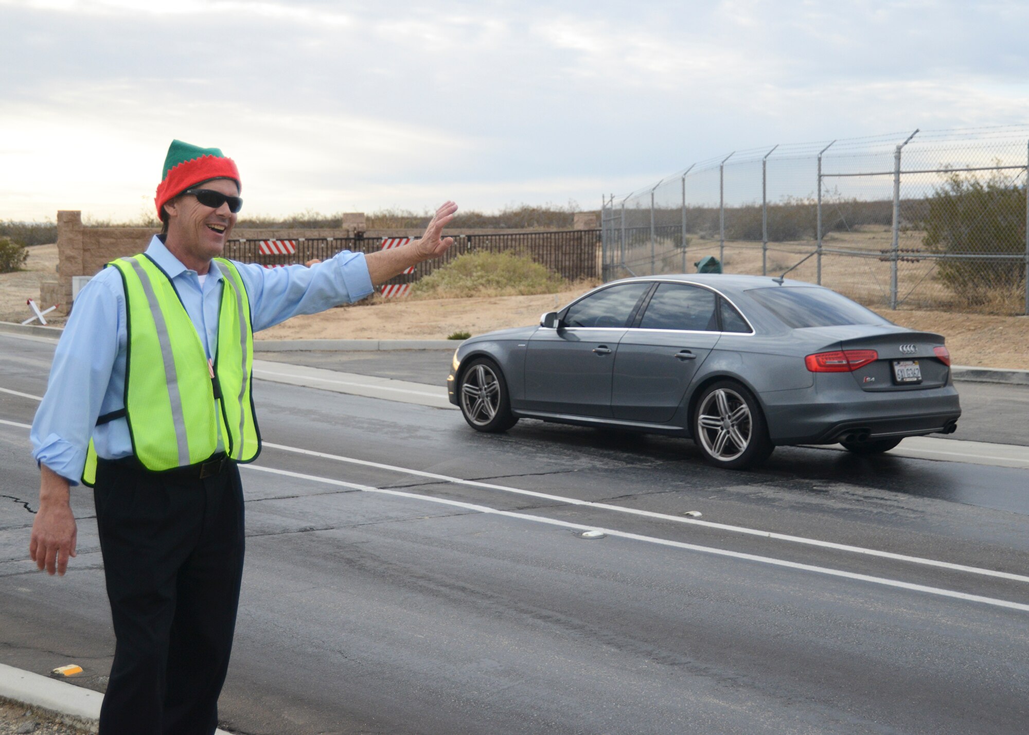 Vince Doss, 412th Logistics Readiness Squadron, waves good bye to motorists towards the end of the work day Dec. 19. (U.S. Air Force photo by Rebecca Amber)