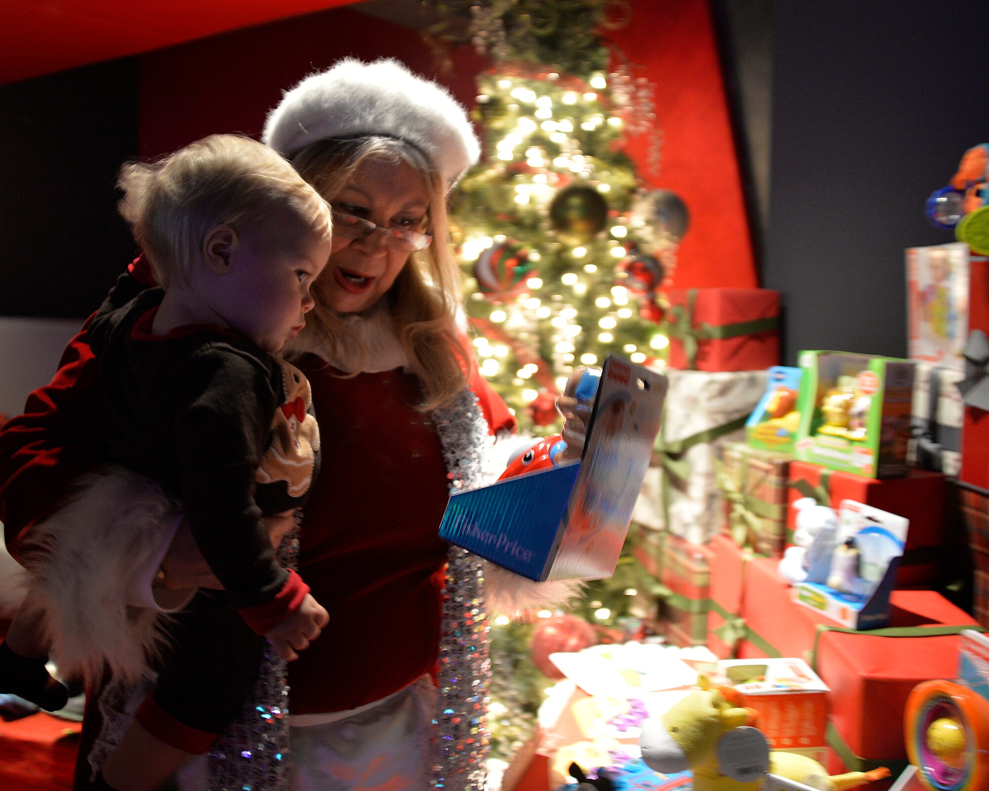 Mrs. Claus helps Aidan Runquist, 1, pick out a special present during a dinner for families Dec. 17, 2014, at the Aliante Casino and Hotel in Las Vegas. Every child who attended the event was able to pick out a present of their choice as a ‘thank you’ from the Las Vegas USO and Gary Sinise Foundation during the holiday season. (U.S. Air Force photo by Staff Sgt. Adawn Kelsey/Released)