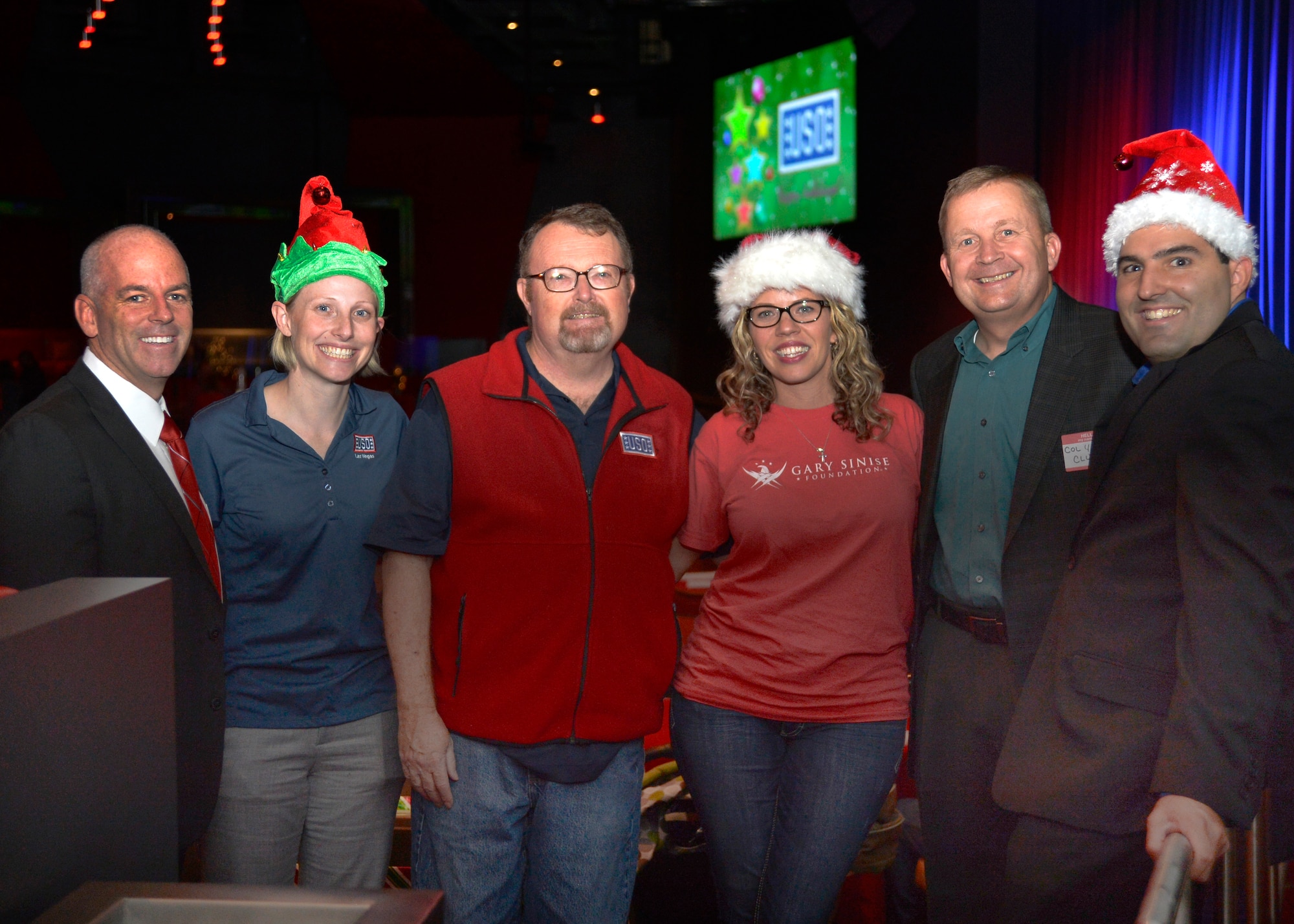 Leadership from the 432nd Wing/432nd Air Expeditionary Wing and volunteers from the Las Vegas USO and Gary Sinise Foundation, pose for a photo during a dinner for families Dec. 17, 2014, at the Aliante Casino and Hotel in Las Vegas. The Las Vegas USO and Gary Sinise Foundation hosted the event for all families and spouses of deployed members in an effort to boost morale and foster existing and new relationships among the Creech and Nellis Air Force Base communities. (U.S. Air Force photo by Staff Sgt. Adawn Kelsey/Released)