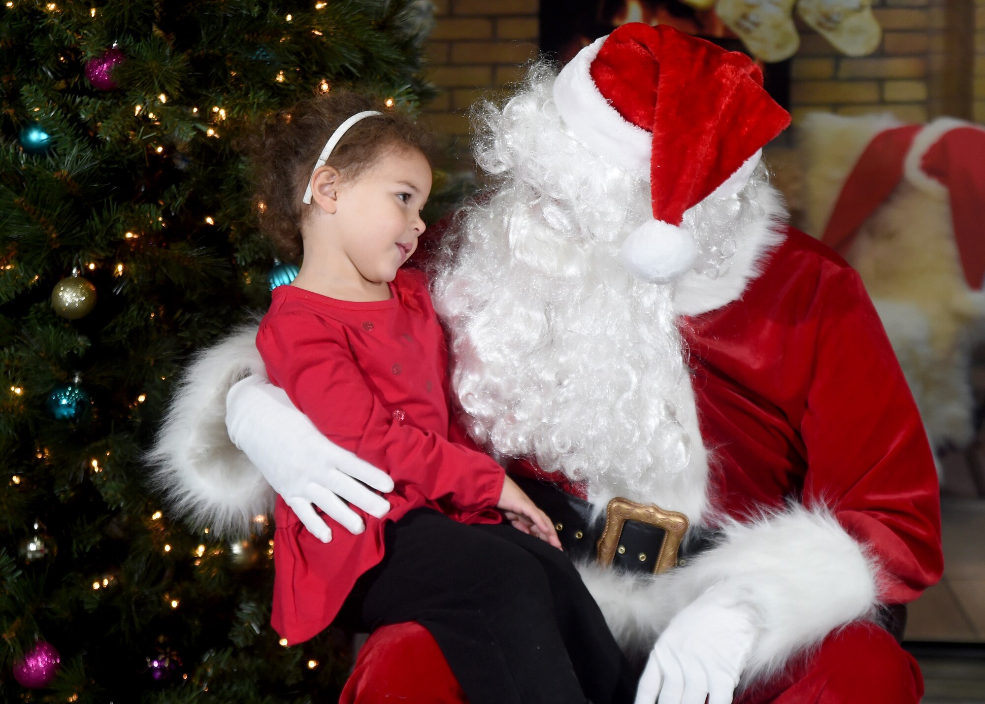 Abigail, four-year-old daughter of Capt. Jessica Brudjar, 432nd Operations Support Squadron chief of training, tells Santa her wish list during the 2014 Children’s Holiday Party at Creech Air Force Base, Nevada, Dec. 13, 2014. Nearly 100 children attended the annual event, which provided food, children’s games, crafts and a visit from Santa for military and civilian Air Force members and their families. (U.S. Air Force photo by Tech. Sgt. Shad Eidson/Released)