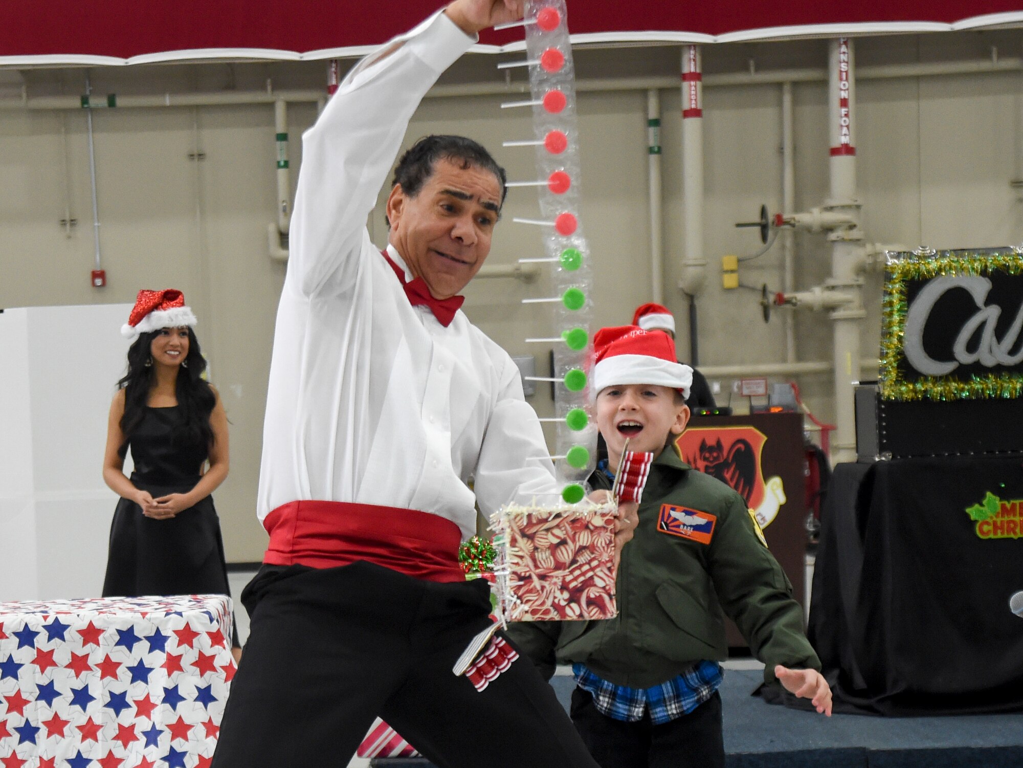 Eight-year-old Beau, son of Lt. Col. Ryan, 11th Reconnaissance Squadron pilot, participates in a magic show during the 2014 Children’s Holiday Party at Creech Air Force Base, Nevada, Dec. 13, 2014. The event provided military and civilian Air Force members and their families with food, children’s games, crafts and a visit from Santa. (Last name has been removed for security purposes.) (U.S. Air Force photo by Tech. Sgt. Shad Eidson/Released)