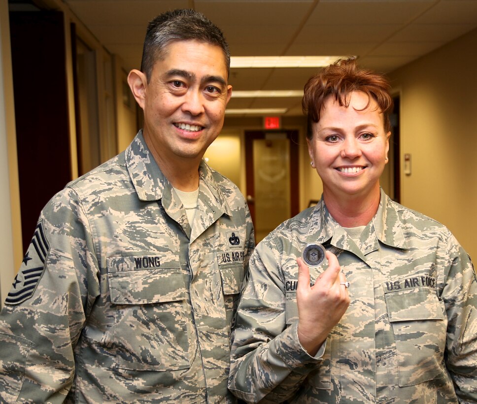 Chief Master Sergeant Brian Wong, Command Chief Master Sergeant, Fourth Air Force, presents a coin to Senior Master Sergeant Shana Cullum for her consistent high quality work throughout the 932nd Airlift Wing.  This was Chief Wong's first visit to Scott Air Force Base. Fourth Air Force has command supervision of the Reserve's long-range airlift and air-refueling units located throughout the continental United States, Hawaii and Guam. (U.S. Air Force Photo/ Staff Sgt. Amber Hodges)