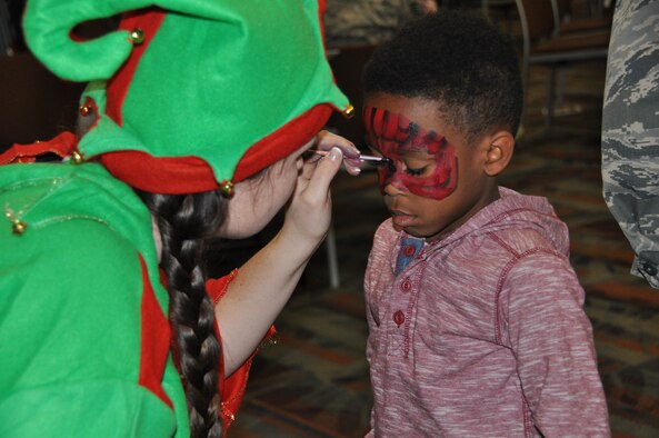 Sparkle the elf paints the face of a child during her visit to the Air Reserve Personnel Center Dec. 19, 2014, on Buckley Air Force Base, Colo. Brig. Gen. Samuel "Bo" Mahaney, Air Reserve Personnel Center commander, introduced Santa Claus and Mrs. Claus, and Sparkle the elf to excited families and children as he discussed the relationship with Santa Claus and the Air Force, which dates back decades. (U.S. Air Force photo/Tech. Sgt. Rob Hazelett)
