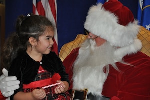 Santa Claus speaks to a child during his visit to the Air Reserve Personnel Center Dec. 19, 2014, on Buckley Air Force Base, Colo. Brig. Gen. Samuel "Bo" Mahaney, ARPC commander, introduced Santa, Mrs. Claus and Sparkle the elf to excited families and children as he discussed the relationship with Santa Claus and the Air Force, which dates back decades. (U.S. Air Force photo/Tech. Sgt. Rob Hazelett)