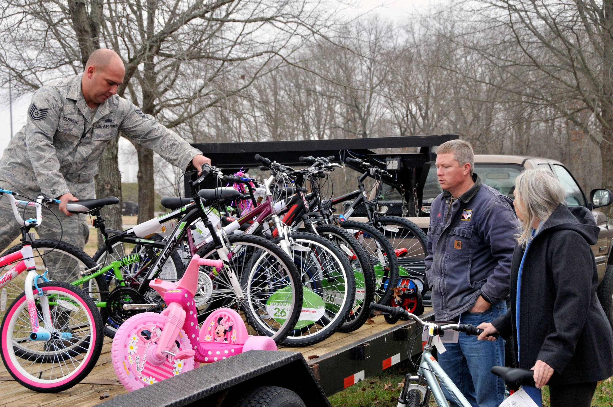 Tech. Sgt. Rodney Clemmons (far left), with the AEDC Test Systems Sustainment Division, places 16 bicycles that were donated for the AEDC Angel Tree program on a flatbed during gift collection at the Complex on Dec. 10. Ben Fletcher (second from left) and Sue Fletcher, with the South Central Relative Caregiver Program, assist Clemmons. The families who are a part of the South Central Relative Caregiver Program and the Healthy Families Program are recipients of the gifts. (Photo by Jacqueline Cowan)