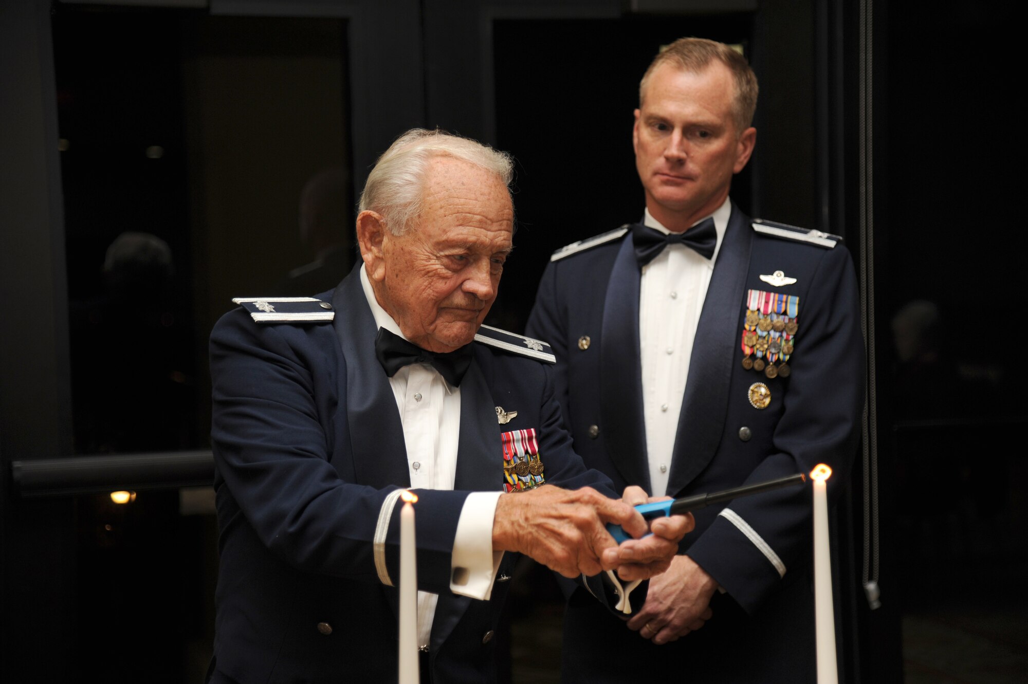 Retired Lt. Col. Dick Wilson, Daedalians member, lights a candle during a ceremony to induct Col. Dennis Scarborough, 81st Training Wing vice commander, into the Order of Daedalians Dec. 18, 2014, at the Bay Breeze Event Center, Keesler Air Force Base, Miss. The Order of Daedalians honors, as its Founder Members, all WW I aviators who were commissioned as officers and rated as military pilots. The Order's membership of commissioned, warrant and flight officer military pilots and WASPs, with its worldwide network of Daedalian Flights and its comprehensive awards program, supports the military services and other aerospace activities.  (U.S. Air Force photo by Kemberly Groue)