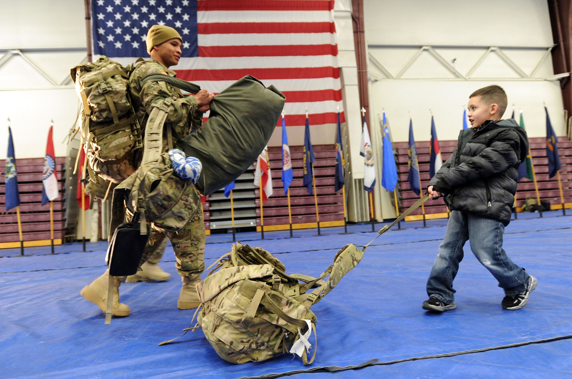 Jovan Antoine Jr., 5, right, pulls his father's rucksack as Army Sgt. Jovan Antoine walks with him after the redeployment ceremony for the 109th Transportation Company, 17th Combat Sustainment Support Battalion, 2d Engineer Brigade, U.S. Army Alaska, at the Buckner Physical Fitness Center, Thursday, Jan. 30, 2014, on Joint Base Elmendorf-Richardson, Alaska.  The Muleskinners of the 109th Transportation Company deployed to Afghanistan in support of Operation Enduring Freedom in June 2013.  While there, they provided transportation and convoy security for military and host nation transportation assets. (U.S. Air Force photo by Justin Connaher/Released)