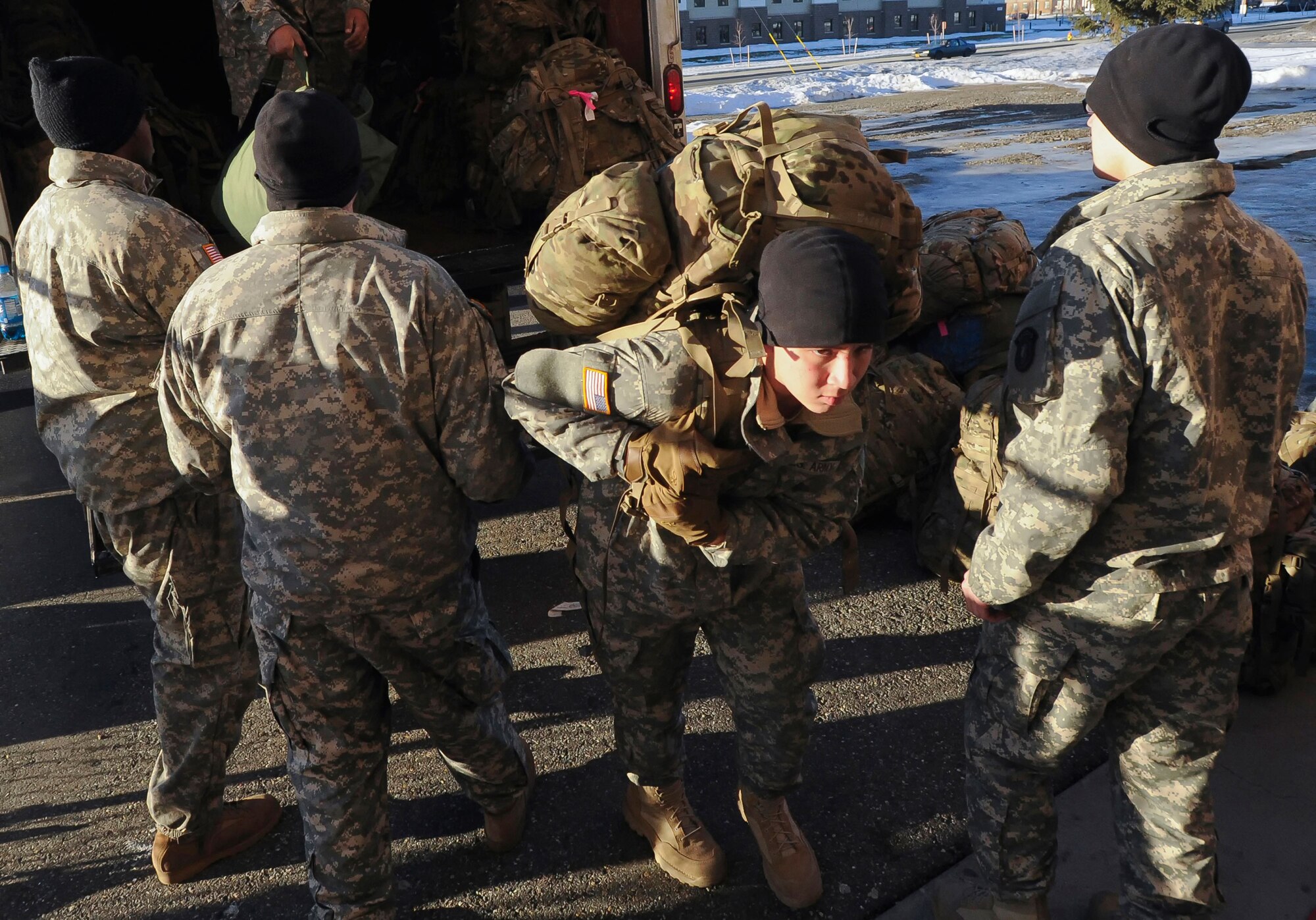 Army Private Graydon Zanyk, assigned to the 98th Maintenance Company, helps unload ruck sacks during the redeployment ceremony for the 109th Transportation Company, 17th Combat Sustainment Support Battalion, 2d Engineer Brigade, U.S. Army Alaska, at the Buckner Physical Fitness Center, Thursday, Jan. 30, 2014, on Joint Base Elmendorf-Richardson, Alaska.  The Muleskinners of the 109th Transportation Company deployed to Afghanistan in support of Operation Enduring Freedom for 7 months, and they provided transportation and convoy security for military and host nation transportation assets. (U.S. Air Force photo/Justin Connaher)