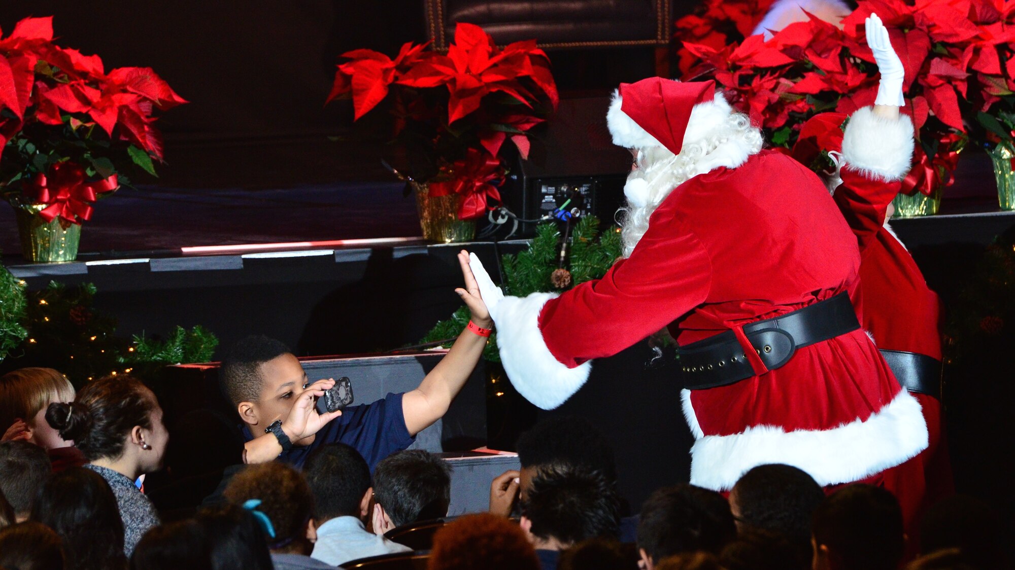 Santa Claus gives an audience member a high-five during The U.S. Air Force Band's 8th annual Holiday Matinee for Kids performance at D.A.R. Constitution Hall on Friday, Dec. 12. (U.S. Air Force photo by Senior Master Sgt. Bob Kamholz/released)
