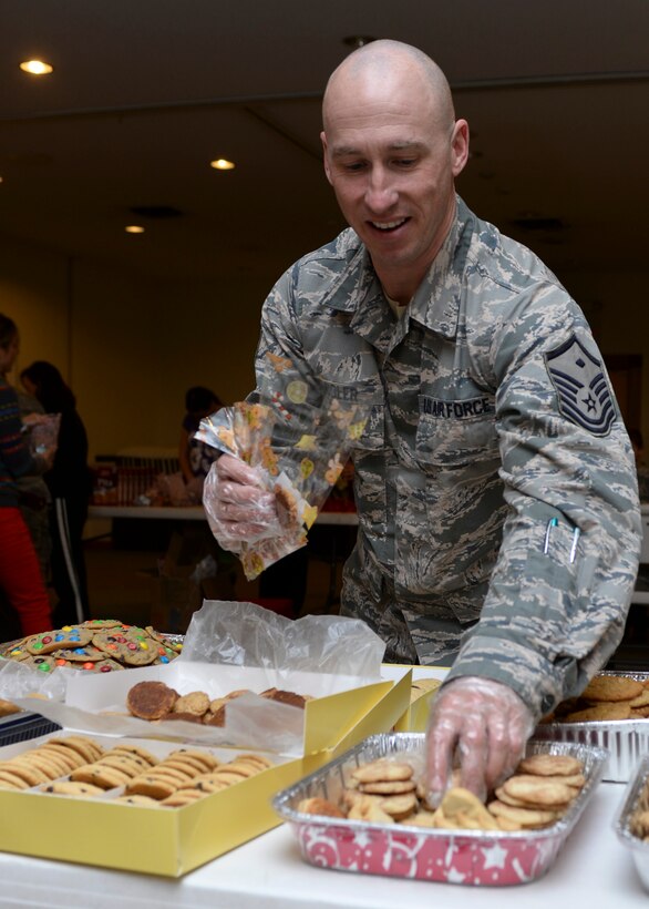 Master Sgt. Joseph Wengler, 28th Civil Engineer Squadron first sergeant, bags cookies during a holiday cookie drive in the Chapel Activities Center at Ellsworth Air Force Base, S.D., Dec. 15, 2014. The event was conducted as a way of encouraging holiday cheer and thanking Airmen for their service. (U.S. Air Force photo by Senior Airman Anania Tekurio/Released)