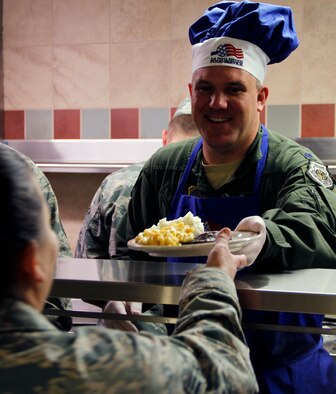 PETERSON AIR FORCE BASE, Colo. Lt. Col. Jason Terry, 52nd Airlift Squadron commander, serves up holiday cheer with lunch at the Aragon Dining Facility here during the December Unit Training Assembly. Senior leaders from throughout the 302nd Airlift Wing participated in the annual tradition of serving a holiday lunch to the wing's Airmen. (U.S. Air Force photo/Staff Sgt. Nathan Federico) 
