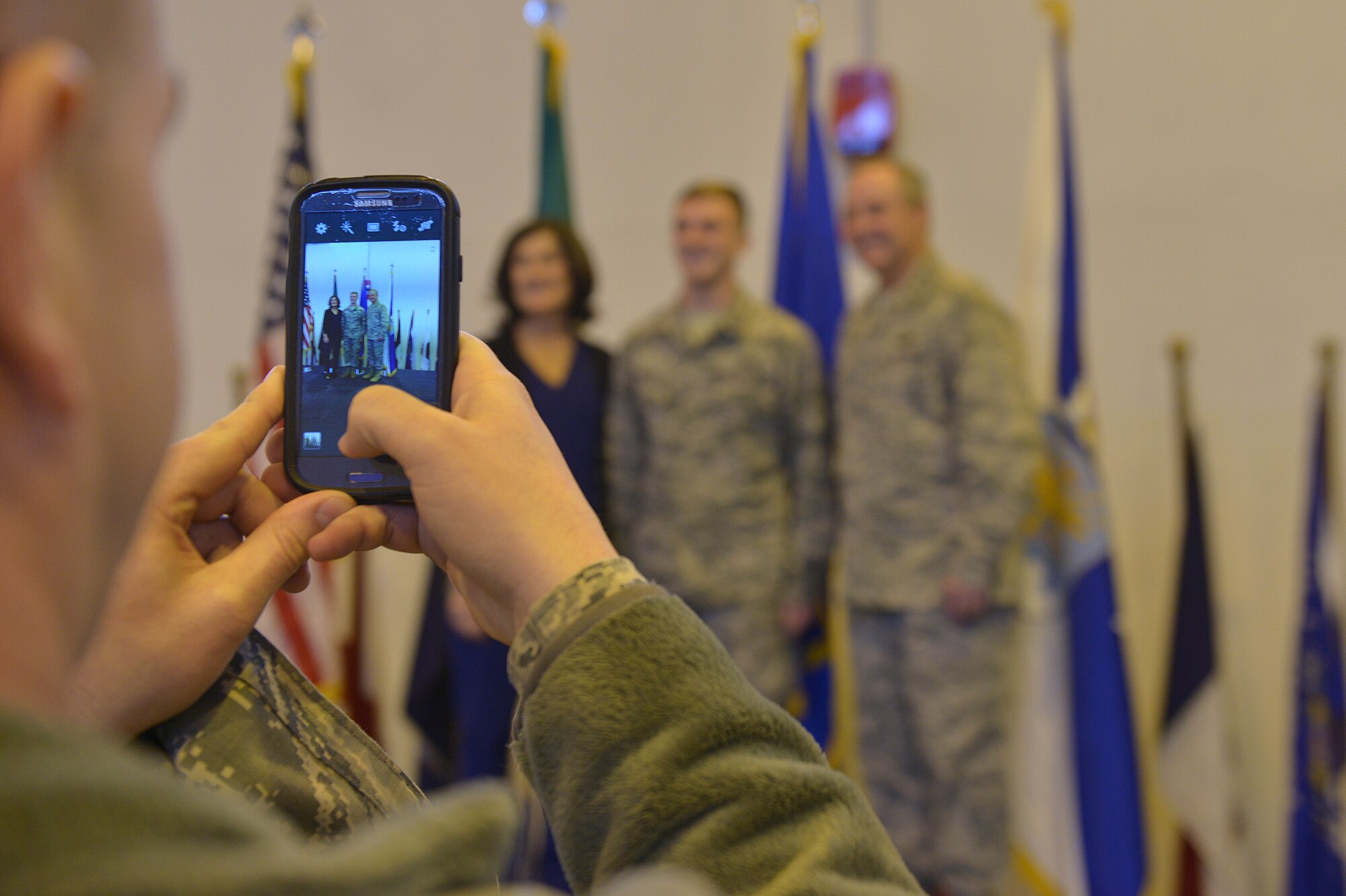 A Team Aviano Airman takes a photo of Gen. Mark A. Welsh III, Air Force Chief of Staff, during a photo session opportunity, Dec. 22, 2014, at Aviano Air Base, Italy. After an all-call, Welsh invited any Airmen who wished to take a photo with him and his wife, Mrs. Betty Welsh, up to the stage. (U.S. Air Force photo/Airman 1st Class Ryan Conroy) 