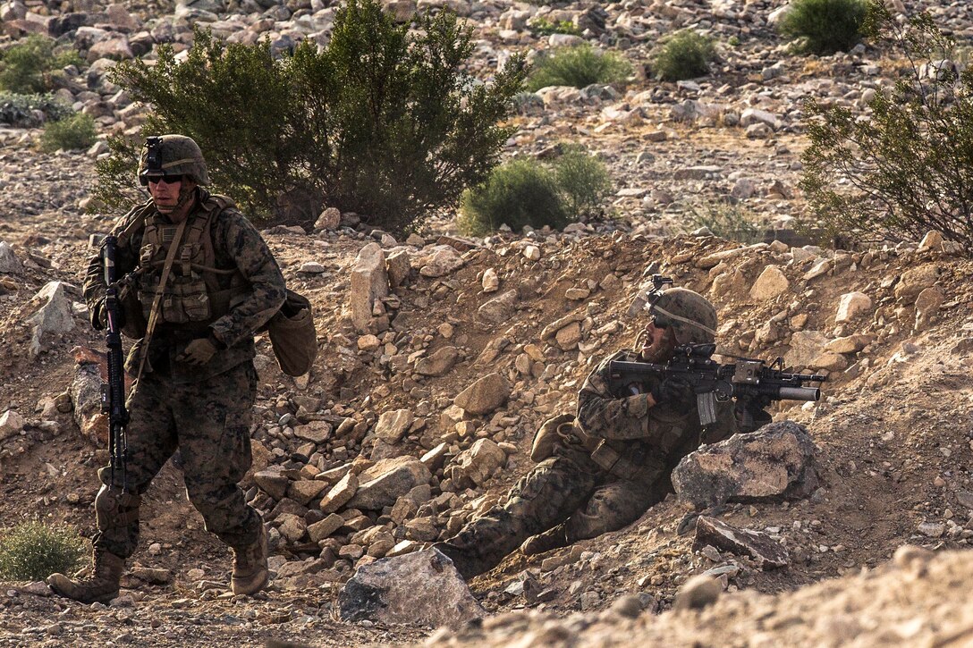 Marine Corps Lance Cpl. Daniel Mclinden, right, directs his Marines during a combined arms exercise on Marine Corps Air Ground Combat Center, Twentynine Palms, Calif., Dec. 15, 2014. Mclinden is a team leader assigned to the Battalion Landing Team, 3rd Battalion, 1st Marine Regiment, 15th Marine Expeditionary Unit.
