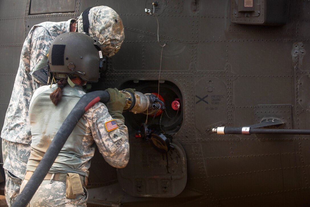 U.S. Army Sgts. Darius Hickson, left, and Stephanie Ziety fuel a UH-60 Black Hawk helicopter in Tapita, Liberia, Dec. 19, 2014. Hickson and Ziety are crew chiefs assigned to the 1st Armor Division's Company B, 2nd Battalion, 501st Aviation Regiment, from Fort Bliss, Texas.
