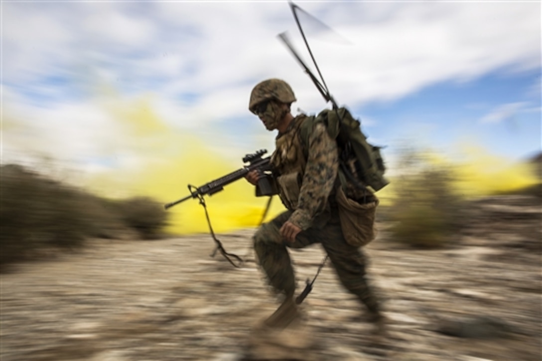 Marine Corps Cpl. Kuamutsua Xiong moves under the concealment of smoke during a combined arms exercise on Marine Corps Air Ground Combat Center, Twentynine Palms, Calif., Dec. 17, 2014. Xiong is a radio operator assigned to the Battalion Landing Team, 3rd Battalion, 1st Marine Regiment, 15th Marine Expeditionary Unit.
