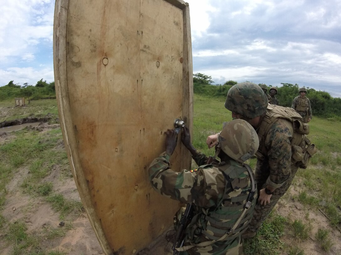 An explosive ordnance disposal technician conducts a breaching class with a soldier with the Ugandan People’s Defense Force in Camp Singo, Uganda, Dec. 2, 2014. Marines and Sailors with SPMAGTF Crisis Response-Africa were in Uganda from Oct. - Dec., training alongside the UPDF, focusing on countering improvised explosive devices, land navigation and logistics. (Courtesy Photo)