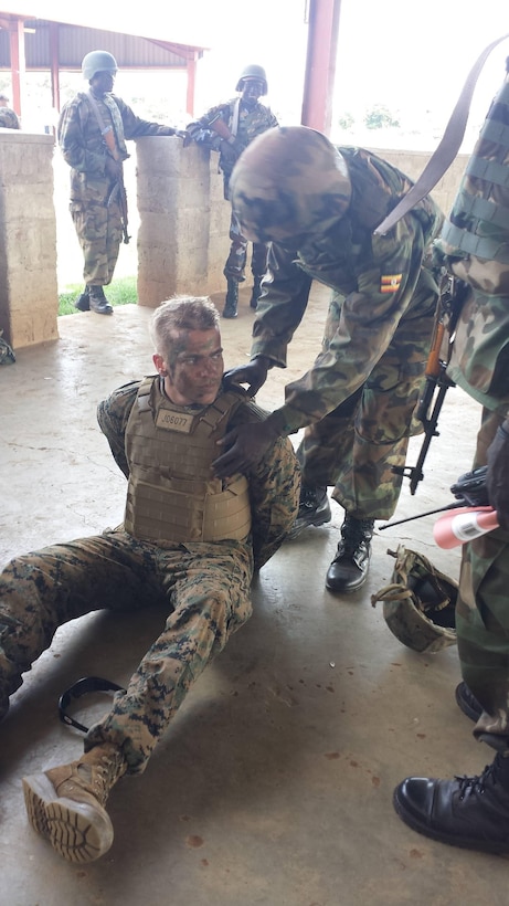 Corporal Caleb Johnson acts as a detainee during a simulated scenario while training with the Ugandan People’s Defense Force in Camp Singo, Uganda, Dec. 10, 2014. Johnson is part of a team of Marines and Sailors with SPMAGTF Crisis Response-Africa who were in Uganda from Oct. - Dec., training with the UPDF, focusing on Infantry tactics, countering IEDs, and logistics.  The Marines and Sailors conducting training in Uganda gained a better understanding and appreciation for the culture of the people of Uganda and the UPDF. (Courtesy Photo)