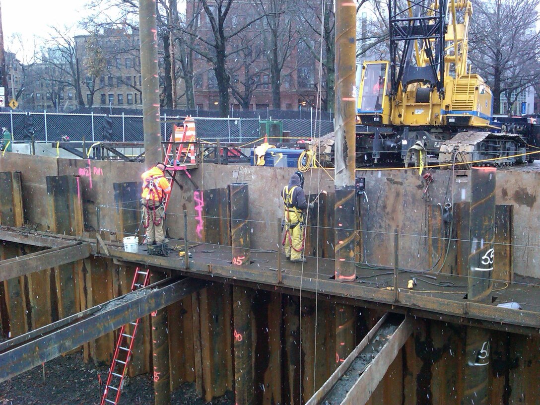 Additional lengths of pipe piles being welded onto already driven pipe piles at the Riverway work area, which is part of the Muddy River Flood Risk Management Project in Boston, Massachusetts.