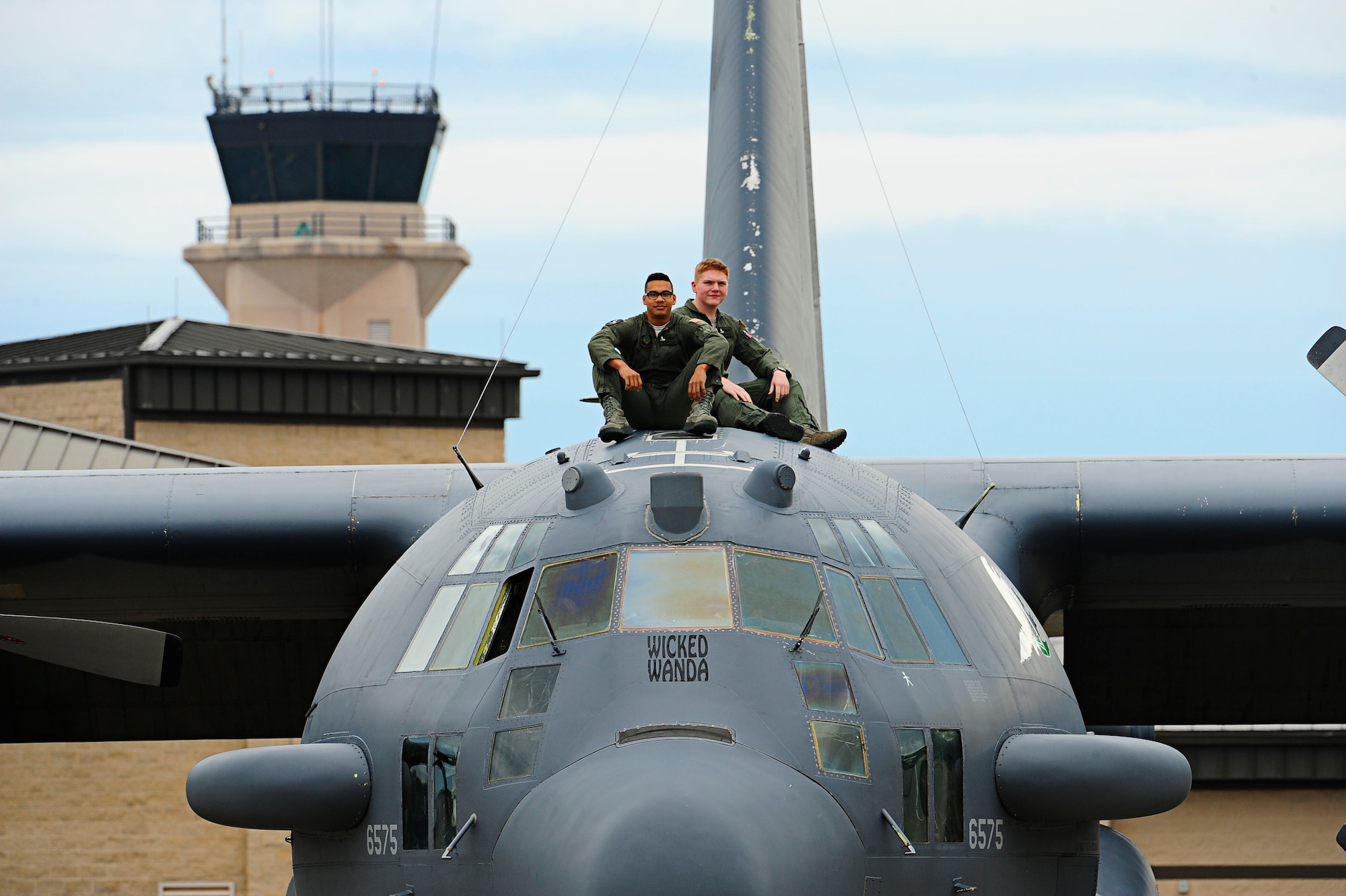 Airman 1st Class Taylor Williams and Ian Robinson, 4th Special Operations Squadron special missions aviators, pose with “Wicked Wanda”, an AC-130H Spectre gunship, on Hurlburt Field, Fla., Dec. 19, 2014. ” Wicked Wanda” was flown during the Iran Hostage Crisis. (U.S. Air Force photo/Senior Airman Desiree W. Moye)