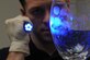 Special Agent Adam Deem shines light on a glass to reveal fingerprints on Barksdale Air Force Base, La. Deem dusted the glass with an orange powder that helps agents detect finger prints with ultraviolet light. Deem serves with Air Force Office of Special Investigation Detachment 219. (U.S. Air Force photo/Airman 1st Class Micaiah Anthony)