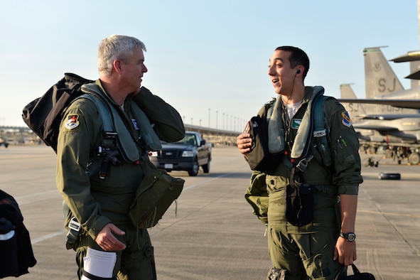 Col. Al Wimmer, left, exchanges a word with his son, Capt. Taylor Wight, before their dissimilar aircraft mission Dec. 12, 2014, at Tyndall Air Force Base, Fla. Wimmer is the director of Air Forces Northern's Operations and Information Operations Directorate and an F-16 Fighting Falcon pilot, and his son, Wight, is the assistant chief of training with the 335th Fighter Squadron at Seymour Johnson Air Force Base, N.C., and an F-15E Strike Eagle pilot. (U.S. Air Force photo/Master Sgt. Kurt Skoglund)