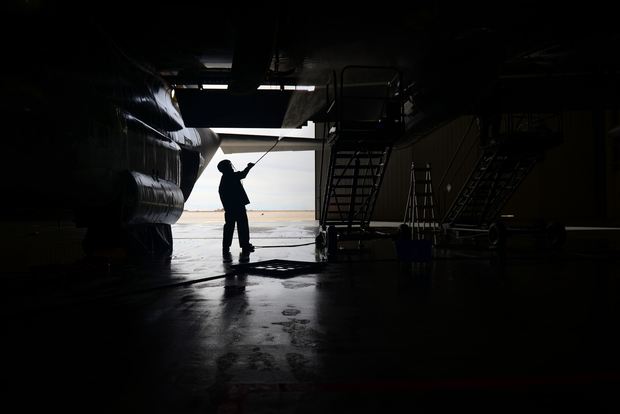 A maintainer from the 27th Special Operations Aircraft Maintenance Squadron uses a pressure washer to rinse soap from an MC-130J Commando II Dec. 18, 2014 at Cannon Air Force Base, N.M. In addition to keeping aircraft clean, scheduled washes help prevent the corrosion of multi-million dollar assets. (U.S. Air Force Photo/Airman 1st Class Shelby Kay-Fantozzi)