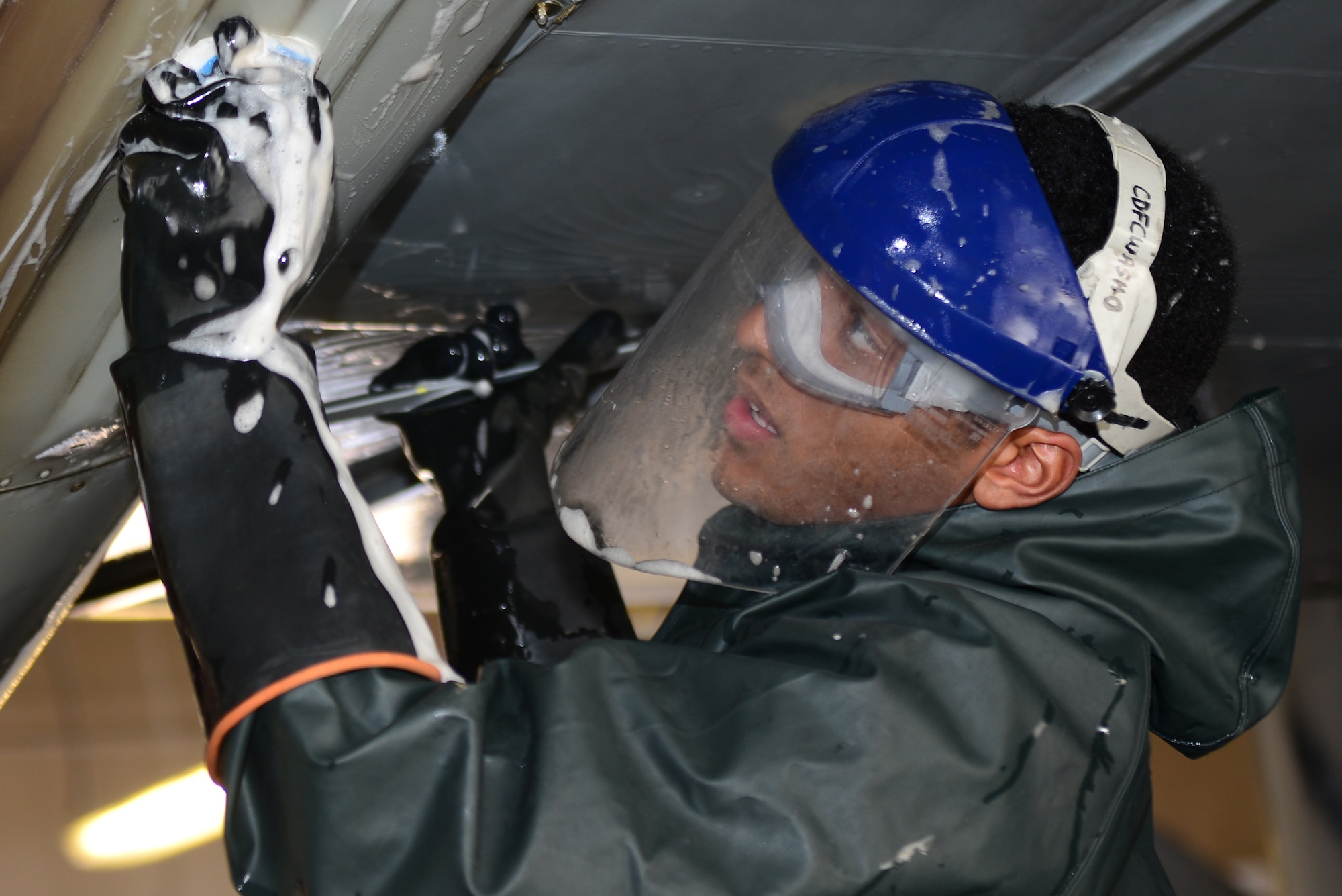 A maintainer from the 27th Special Operations Aircraft Maintenance Squadron scrubs beneath the wing of an MC-130J Commando II Dec. 18, 2014 at Cannon Air Force Base, N.M. Maintainers can spend hours washing an aircraft to ensure it is free of debris and safe from deterioration.  (U.S. Air Force Photo/Airman 1st Class Shelby Kay-Fantozzi)