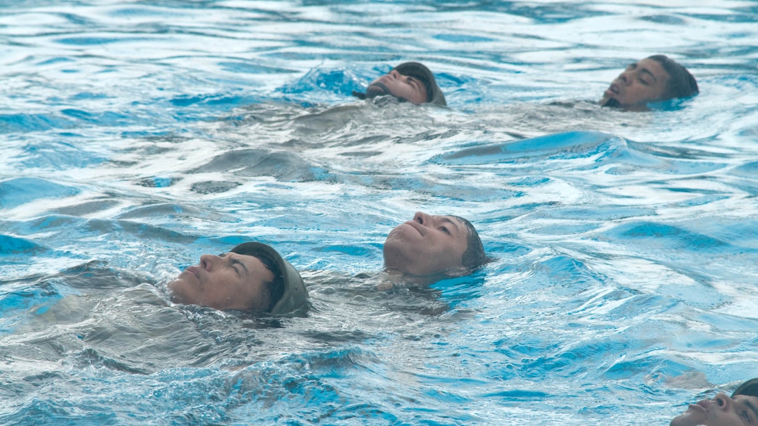 Marines training in the Marine Combat Instructor of Water Survival course drill rescues with their classmates at the Marine Corps Base Hawaii pool, Dec. 12, 2014. A total of 18 Marines were tested this week. 