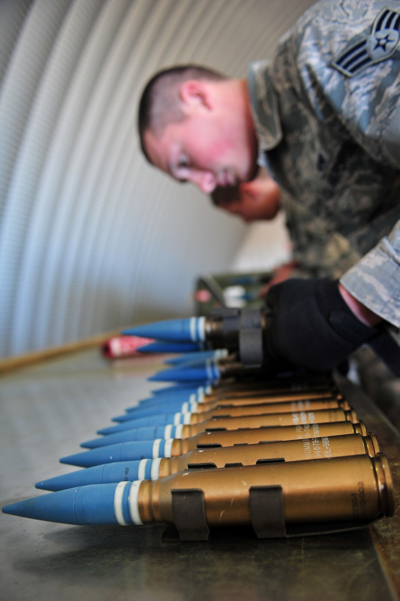 A maintainer with the 27th Special Operations Maintenance Squadron inspects 30 millimeter ammo rounds Dec. 18, 2014 at Cannon Air Force Base, N.M. Munition systems specialists receive, identify, inspect and store guided and unguided nonnuclear munitions. (U.S. Air Force photo/Senior Airman Eboni Reece)