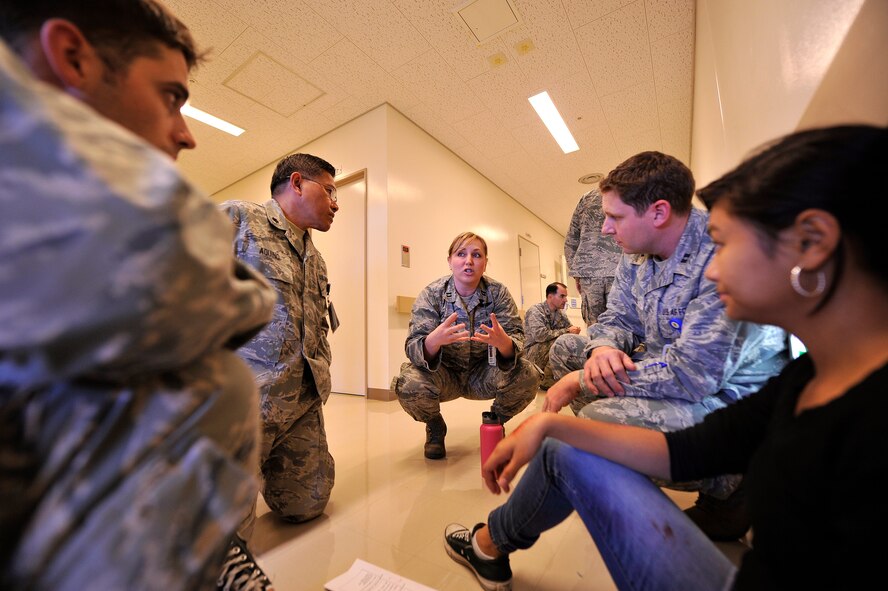 U.S. Air Force Capt. Randi Ewing, 18th Medical Operations Squadron family health clinic element leader from family health clinic, explains the first steps of triage to members of the healthcare profession during disaster team training on Kadena Air Base, Japan, Dec. 18, 2014. During the training, three U.S. Navy personnel and roughly 90 healthcare providers focused on triaging accident victims. Triage is the first step in sorting out victims of accidents and disasters and is a vital step in preserving life, limb, and eyesight. (U.S. Air Force photo by Naoto Anazawa)
