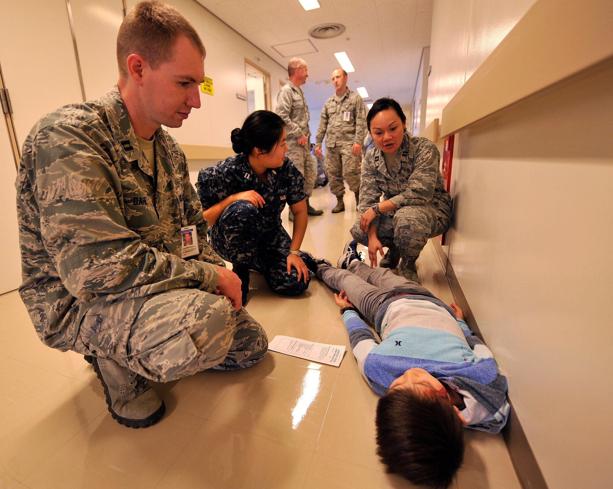 Military healthcare providers diagnose a simulated accident victim during disaster team training on Kadena Air Base, Japan, Dec. 18, 2014. The 18th Medical Group conducted disaster team training with their counterparts from the U.S. Naval Hospital on Okinawa and the 3rd Medical Battalion on Camp Foster. During the training, three U.S. Navy personnel and roughly 90 healthcare providers focused on triaging accident victims. (U.S. Air Force photo by Naoto Anazawa)