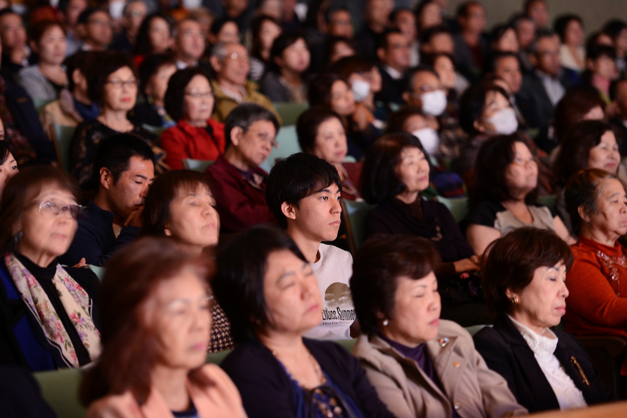Audience members listen to performers during the U.S. Air Force Band of the Pacific-Asia jazz ensemble friendship concert in Naha, Japan, Dec. 11, 2014. During the two-hour concert, members of the band sang, danced and played to an audience of more than 450 local Okinawan citizens as a way to return some hospitality to the host nation. The concert was one of four during the band's tour of Okinawa. (U.S. Air Force photo by Senior Airman Maeson L. Elleman)