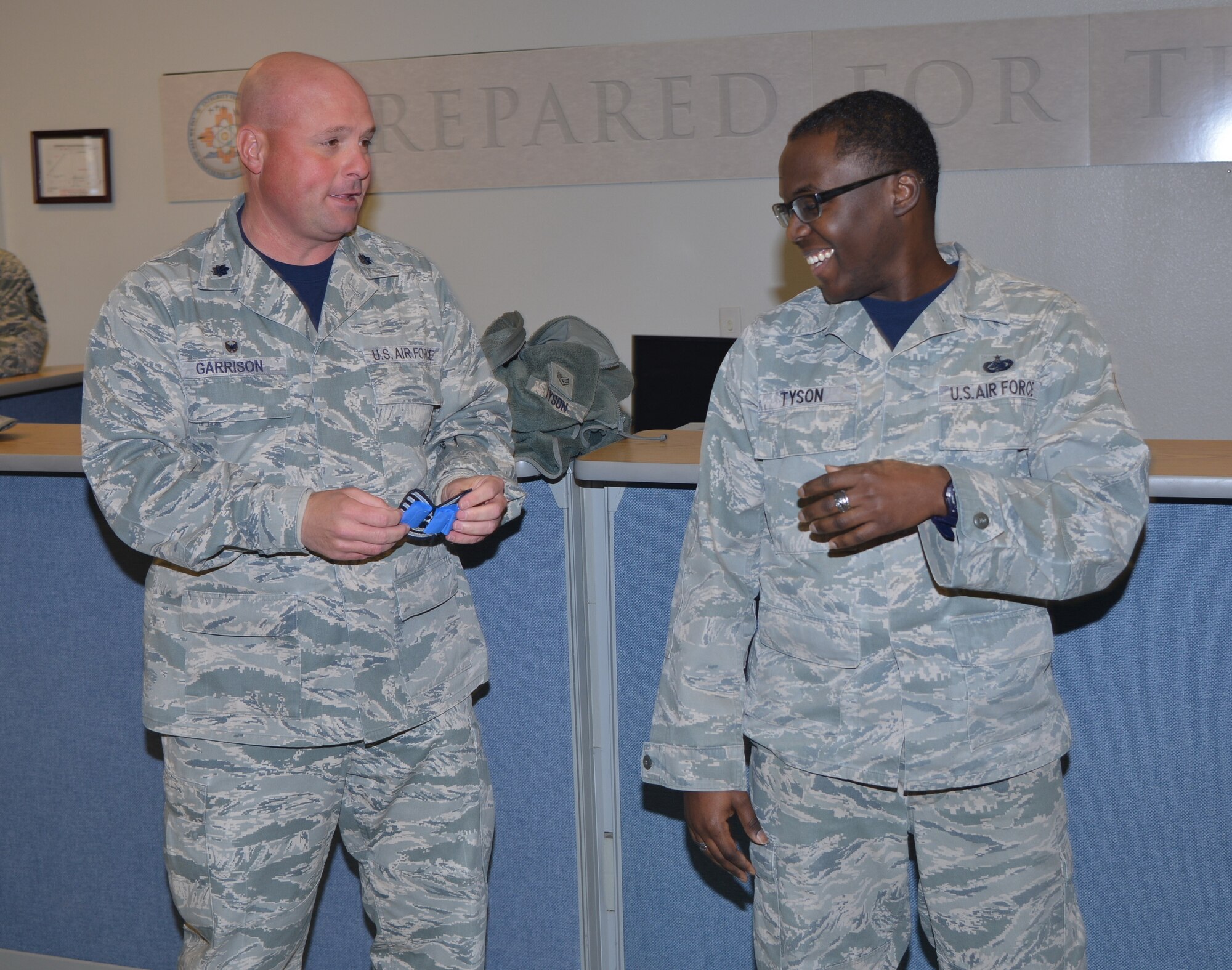 Lt. Col. Robert Garrison, left, 377th Logistics Readiness Squadron commander, surprises Staff Sgt. Jameel Tyson with new stripes.  Tyson, NCO in charge of logistics plans for the LRS, was STEP promoted to technical sergeant. The Stripes for Exceptional Performers program allows commanders the opportunity to immediately promote enlisted Airmen who exhibit exceptional potential but have been unable to meet the cutoff for promotion in terms of points. Among his many accomplishments, Tyson received the AFMC Logistics Plans NCO of the Year Award and was a John L. Levitow award winner for exemplary demonstration of excellence, both as a leader and a scholar, at Airman Leadership School.  (Photo by Todd Berenger)