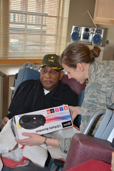 1st Lt Cristi Jordan, 507th Operations Group helps a resident of the Normans Veterans Center open a gift Dec. 22. (U.S. Air Force Photo/Maj. Jon Quinlan)