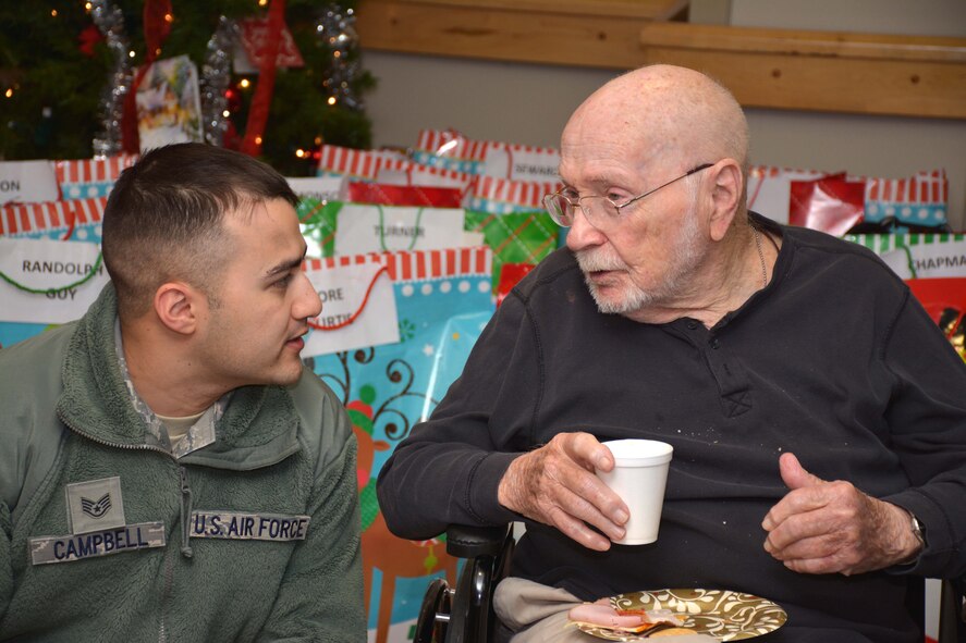 Staff Sgt. Anthony Campbell, 137th Air Refueling Wing, Oklahoma Air National Guard, listens to a veteran at the Norman Veterans Center Dec. 22.  (U.S. Air Force Photo/Maj. Jon Quinlan)