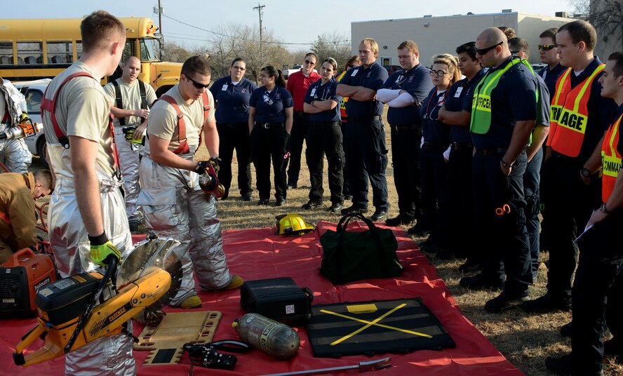 Dyess firefighters from the 7th Civil Engineer Squadron explain different tools they use to extricate patients from vehicles to emergency medical technician students from Texas State Technical College Dec. 12, 2014, at Abilene, Texas. The firefighters explained the different tools and techniques they would use to remove patients trapped inside vehicles. Generally, Dyess and Abilene emergency medical services work together, each providing specific capabilities during real-world events. (U.S. Air Force photo by Senior Airman Peter Thompson/Released)